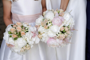 due damigelle tendgomno in mano un bouquet di fiori