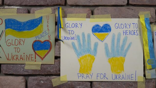 Ukrainian children's drawings for peace against the 2022 Russo-Ukrainian War are placed on the brick wall of the bomb shelter.