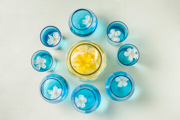 Flores de cerezo flotando en copas azules, ambiente primaveral y fresco de decoración