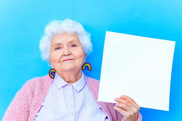 mature woman with snow white grey white hair in pink cardigan and blue shirt wear rainbow colorful...