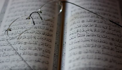 Foto op Plexiglas glasses over the open Koran © corradobarattaphotos