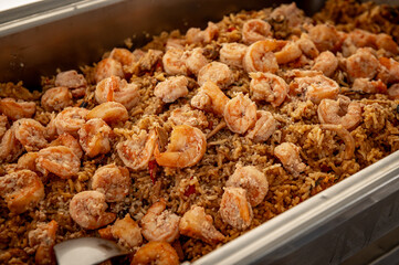 Banquet table with chafing dish heaters. Rice with shrimp