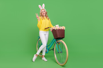 Photo of funny cute lady dressed yellow pullover headband driving cycle showing v-sign isolated...