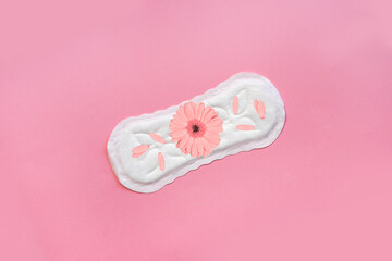 The sanitary napkin lying with blossom on pink background