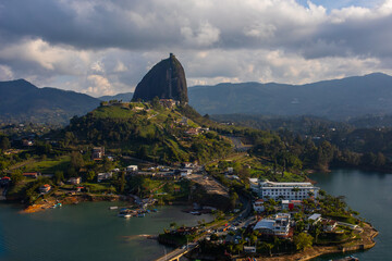 Beautiful photo of a huge natural black rock El Pe&ntilde;ol from a bird's eye view, against the backdrop of mountains, and a lake, Guatape, Colombia