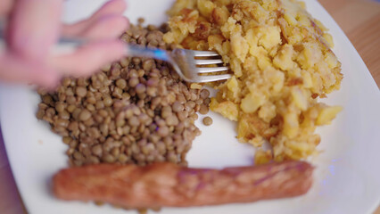 Plate with roasted potato, lens and sausage top view
