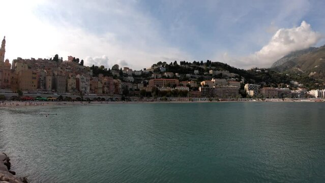 Menton, France, October 2, 2021: PAN SHOT - The Sablettes beach in Menton is located between the two ports (the Old Port and Garavan), along the Quai Bonaparte and the old town.