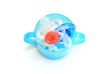 Child soothers in a blue baby cup. Red white and blue colours