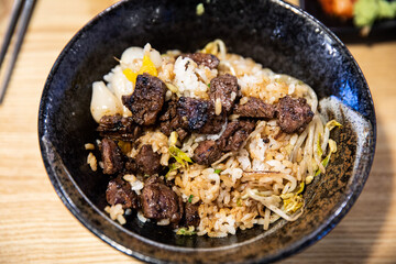 Steak bowl with beef steak, rice, mustard, vegetables, green onion, and greens,