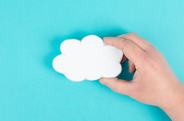 Holding a white cloud in the hand, empty copy space for text, blue background, communication and marketing concept, being connected, networking