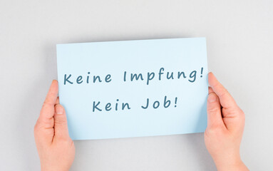 Paper wih the words no vaccine, no job, mandatory syringe for covid-19, employee termination for anti jab, german langauge
