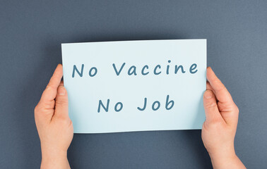 Paper wih the words no vaccine, no job, mandatory syringe for covid-19, employee termination for...