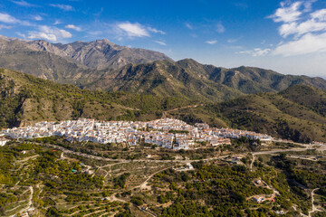 Fototapeta na wymiar Perspective from above of beautiful typically Spanish village. White village situated in top of the hills in South of Spain. European, touristic travel destination in Andalucía. Drone perspective