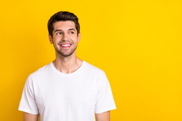 Fototapeta premium Photo of interested smart minded nice man look empty space wear white t-shirt isolated yellow color background