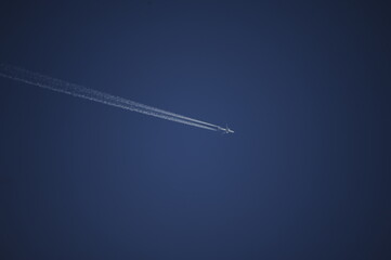 Aereo e scia di condensazione su cielo terso