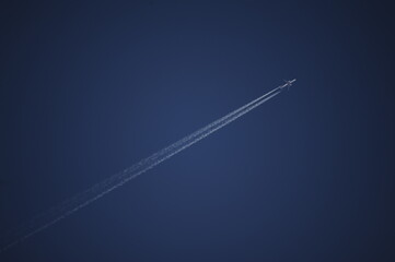 Aereo e scia di condensazione su cielo terso