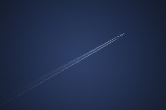 Aereo e scia di condensazione su cielo terso