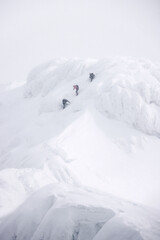 Fototapeta na wymiar Group of alpinists trekking in harsh winter conditions in the Transylvanian Alps, Romania, Europe
