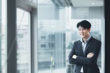 Fototapeta premium Asian man with suit, young businessman as startup company CEO, executive room, young startup company executives, run by young leaders. Management concept of startup companies and business men.