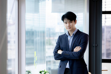 Fototapeta premium Asian man with suit, young businessman as startup company CEO, executive room, young startup company executives, run by young leaders. Management concept of startup companies and business men.
