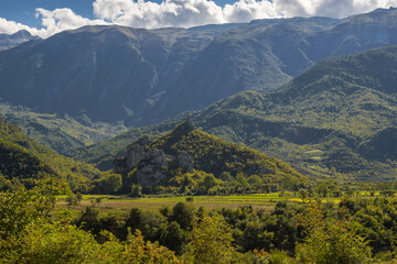 Naklejka na ściany i meble Beautiful mountain valley with gentle hills and agricultutal filds