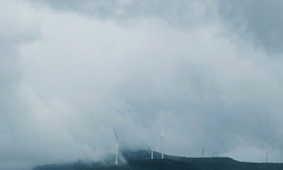 Fototapeta premium Windmills with fog on mountain