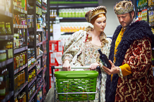 Its a vintage fit for a king and queen. Shot of a king and queen looking at goods while shopping in a modern grocery store.