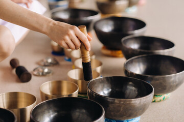 Close-up of a Tibetan singing bowl in your hands - Translation of mantras: transform your impure body, speech and mind into a pure exalted body, speech and mind of a Buddha