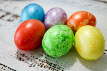 colorful easter eggs on wooden kitchen table close up