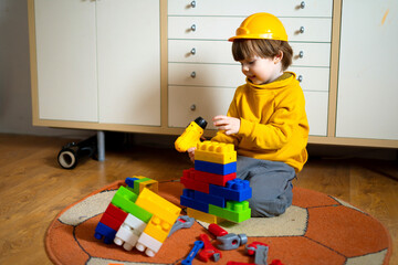 Baby girl builds a tower of  cubes. Child playing with  cubes on the floor