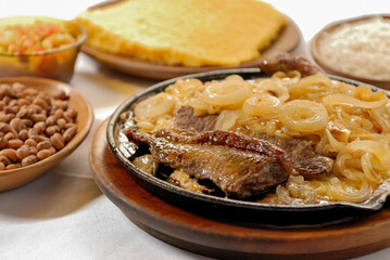 Sun meat with onion, accompanied by northeastern couscous and green beans. Carne de Sol dish of northeastern Brazilian cuisine.