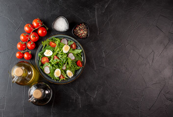 Salad with cherry tomatoes, fresh arugula and quail egg. Concept for a tasty and healthy meal. Vitamins in vegetables. Top view. Flat lay, copy space