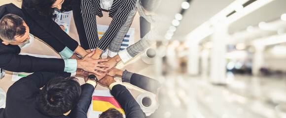 Happy business people celebrate teamwork success together with joy at office table shot from top...