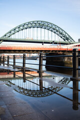 Newcastle/UK - 18/01/2020 : Tyne Bridge on Newcastle Quayside with reflection in puddle after rainstorm