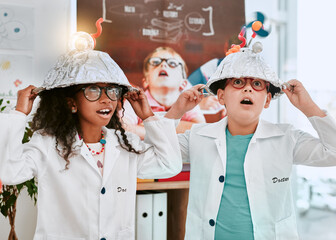 Were well known for our bright ideas. Shot of two adorable young school pupils doing an experiment about electricity and light in science class at school. - Powered by Adobe