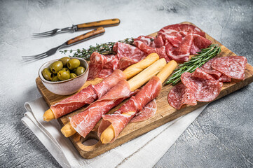 Antipasto platter cold meat plate with grissini bread sticks, Prosciutto crudo, Salami and Coppa Sausage. White background. Top view