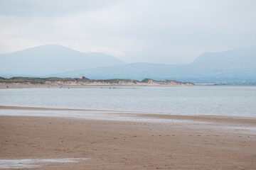 Llanddwyn beach on Anglesey Island in north Wales, with Snowdonia mountains seen across the water