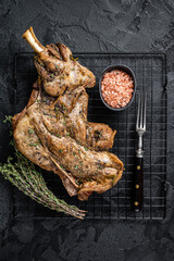 Barbecue Roasted lamb mutton shoulder meat with herbs and spices. Black background. Top view
