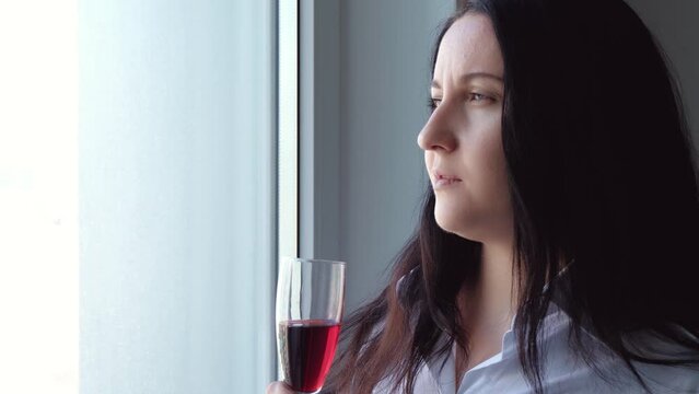 Portrait Of A Business Woman With A Glass Of Wine. A Woman Looks Out The Window And Drinks Wine.