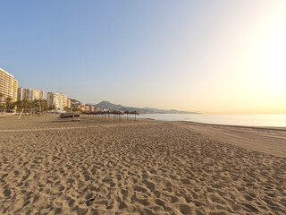 La Malagueta urban sand beach at sunset golden light on the Costa del Sol, Malaga city center, Spain, Europe