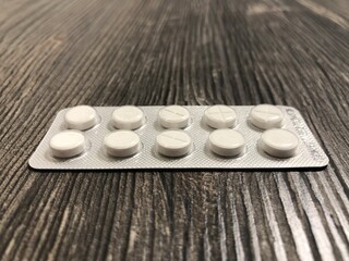 The pills lying on the wooden table. The pills close up.