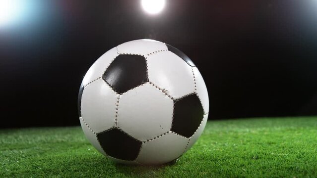 Super slow motion of rotating soccer ball on lawn. Filmed on high speed cinema camera, 1000fps. Speed ramp effect.