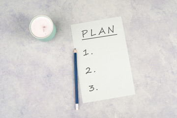 Empty paper with a pen on a textured background, the word plan is standing on the top of the page, planning new goals, to do list, cup of coffee