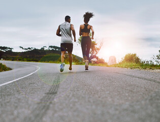 Staying in top form together. Rearview shot of a sporty young couple exercising together outdoors.