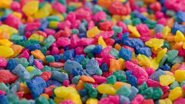 crushed colored stones on flat surface, slowly spinning, loopable closeup