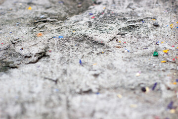 close up of rock surface with colorful paper specs