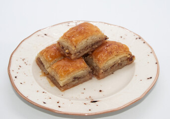 turkish dessert bakalva, five pieces of baklava on white plate and white background, isoleted, close up 