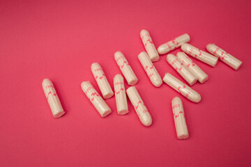 Medical female tampon on a pink background. Hygienic white tampon for women. Cotton swab. Menstruation, means of protection.