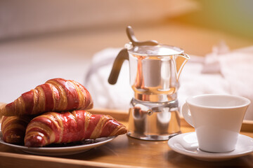 Breakfast on a bed in a hotel room.