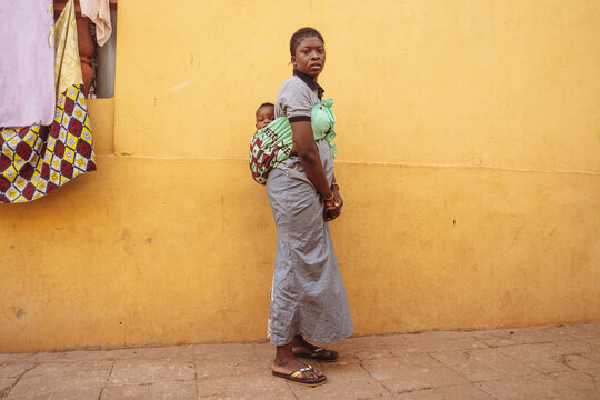 Portrait of mother and son.African Woman carrying her baby boy on her back in a street in Bamako,Mali.